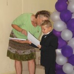 Noah receiving graduation certificate from Debbie